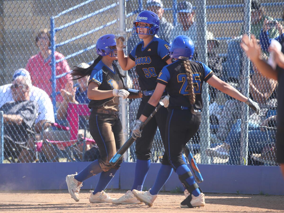 Marissa Sardinas (7), Makenzie Butt (98), and Samantha Estrada (25), from left, celebrate a run against Upland on Tuesday.