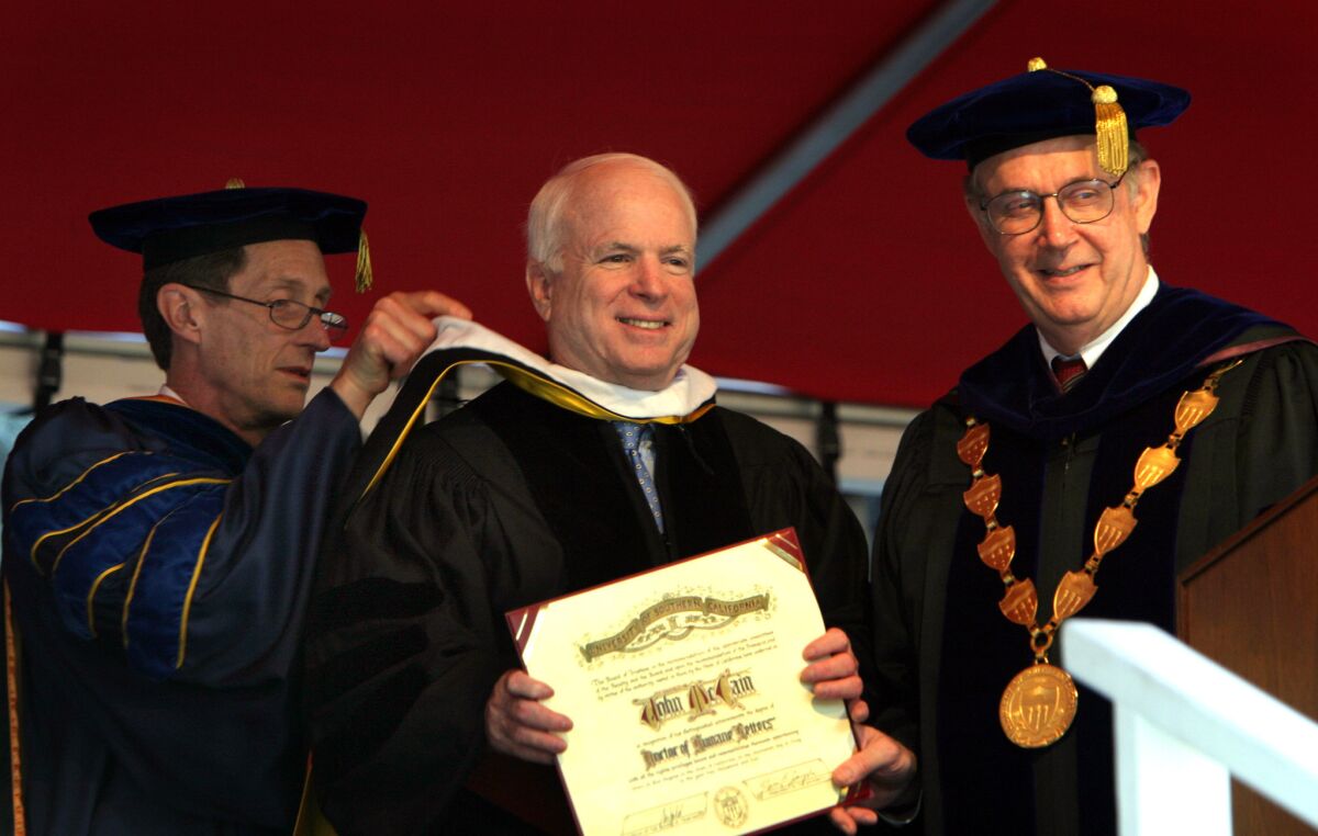 USC President Steven B. Sample, right, and Provost Lloyd Armstrong Jr., left, confer an honorary degree to U.S. Sen. John McCain (R-Ariz.), who delivered the commencement address at USC in 2004.