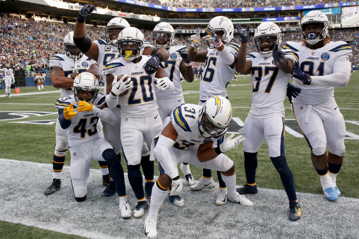 Desmond King II #20 of the Los Angeles Chargers celebrates with teammates after scoring a touchdown from an interception in the fourth quarter against the Seattle Seahawks at CenturyLink Field on November 04, 2018 in Seattle, Washington.