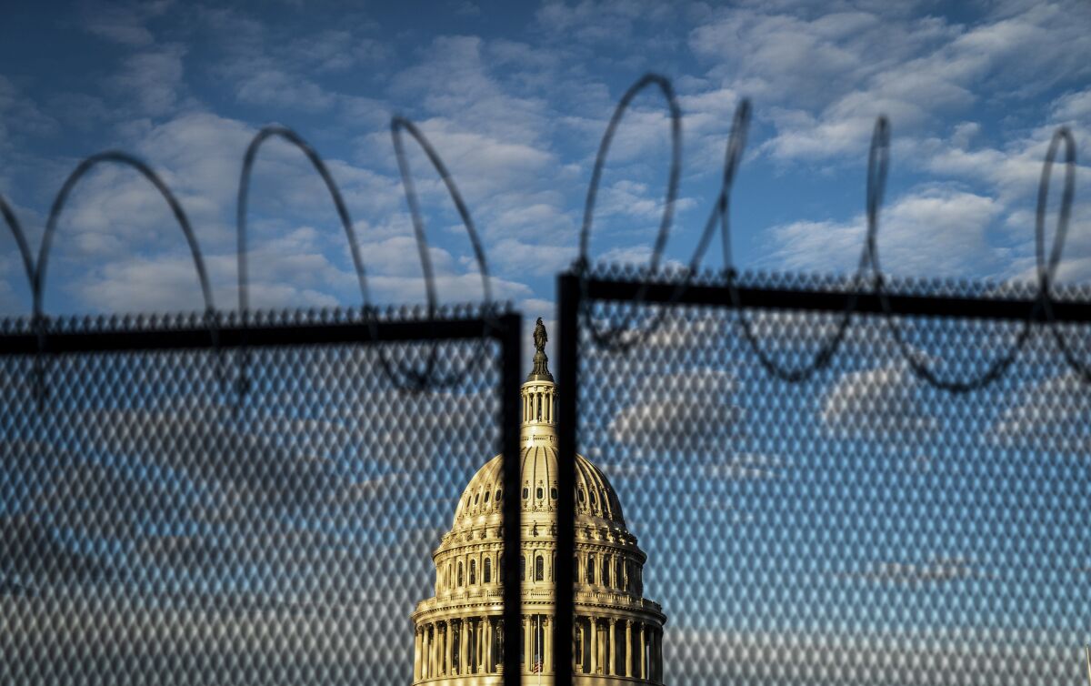 Barbed wire security fencing with the dome of the U.S. Capitol Building on Saturday, Jan. 16, 2021 in Washington, D.C. 