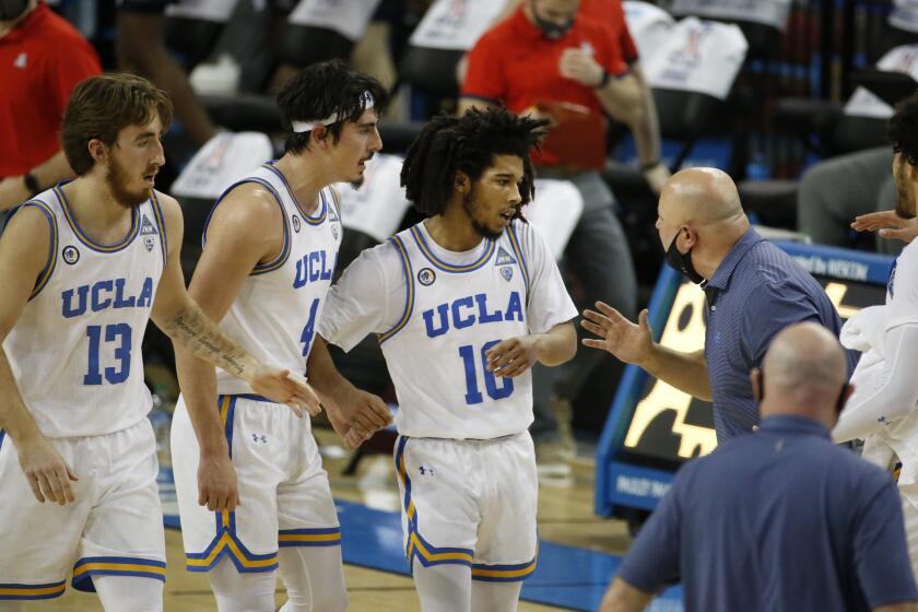 UCLA head coach Mick Cronin talks to his players during an NCAA college basketball game.