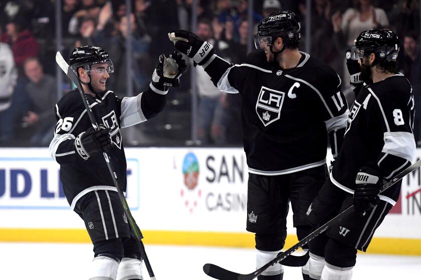 LOS ANGELES, CALIFORNIA - NOVEMBER 12: Sean Walker #26 of the Los Angeles Kings celebrates his empty goal with Anze Kopitar #11 and Drew Doughty #8 during the third period in a 3-1 Kings win over the Minnesota Wild at Staples Center on November 12, 2019 in Los Angeles, California. (Photo by Harry How/Getty Images)