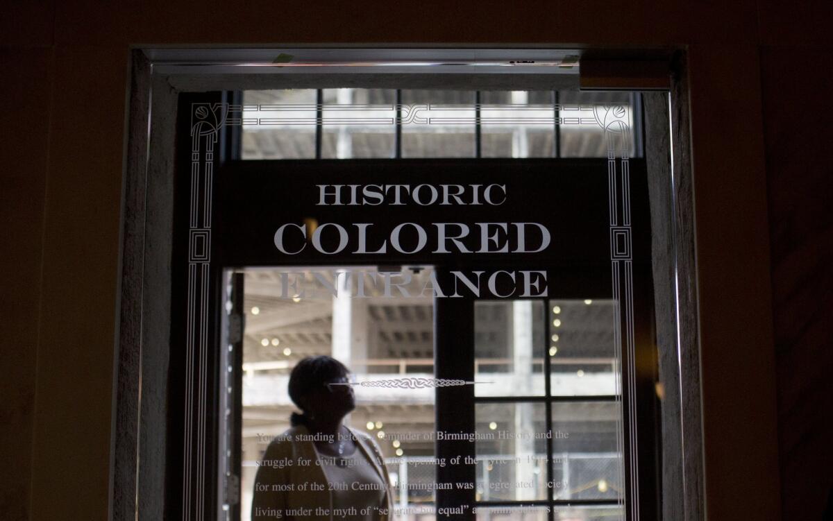 A woman stands in the doorway of the new Historic Colored Entrance at the Lyric Theatre, in Birmingham, Ala. on Jan. 7.