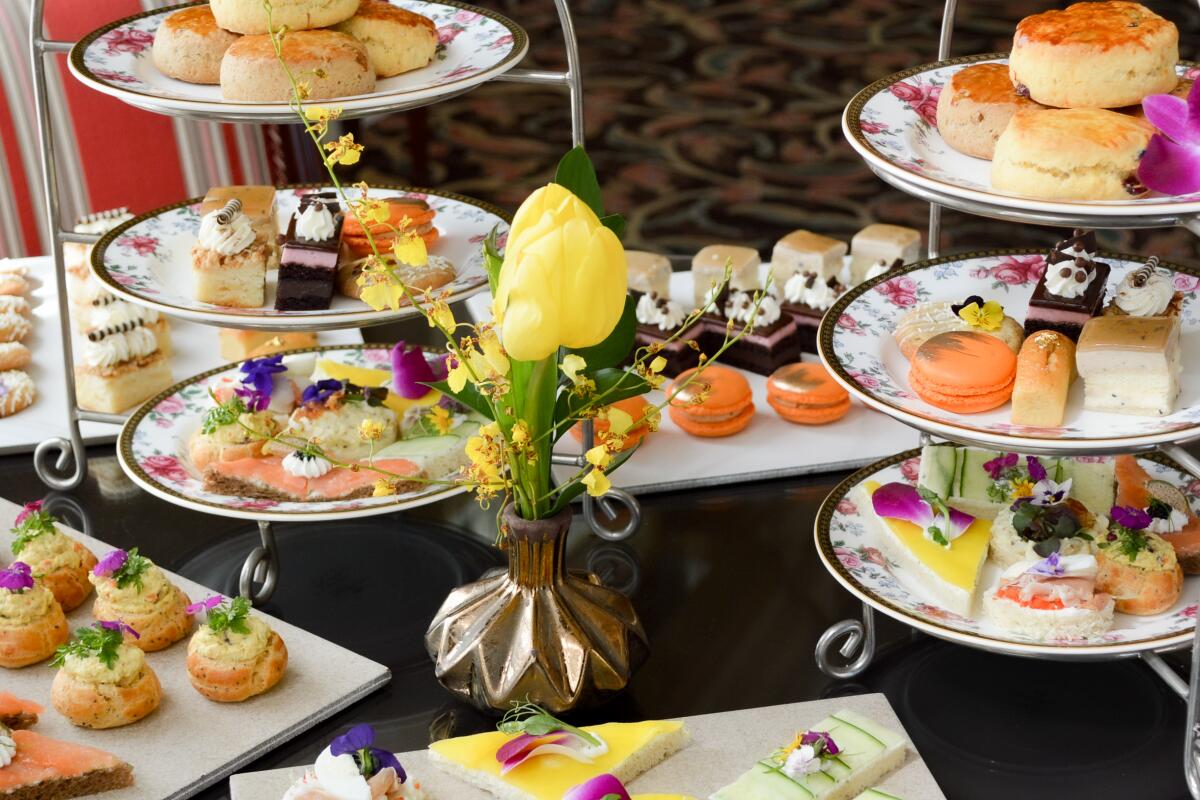 Traditional British tea service with sandwiches and sweets.