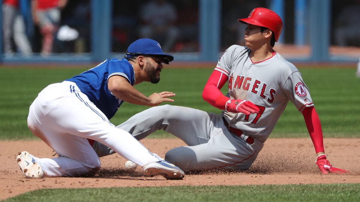 Shohei Ohtani arrives safely at second base as Toronto's Devon Travis cannot handle the throw.