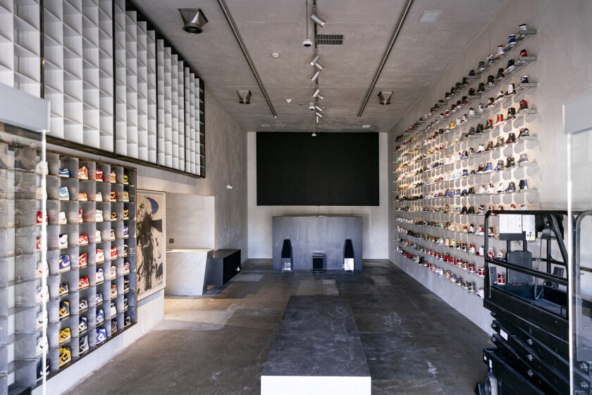 The inside of a building with shoes stacked on walls to the left and right.