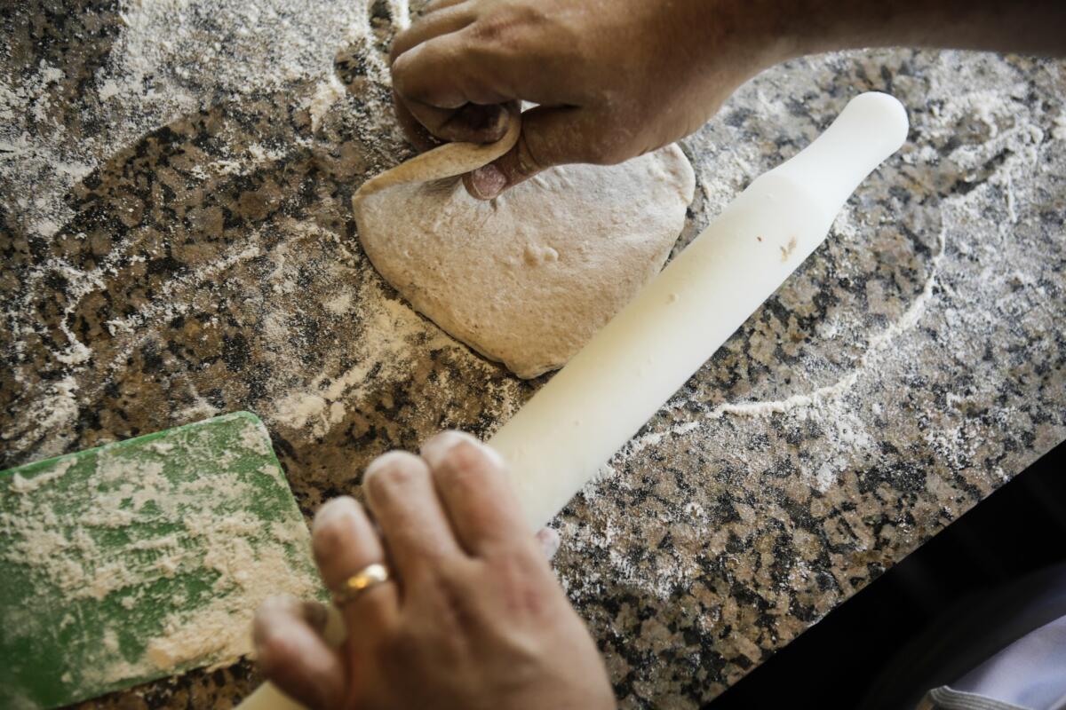 Dough is flattened as part of the process to make your own pita bread.