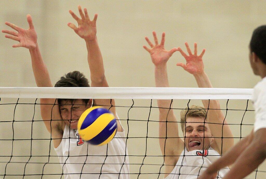 Orange Coast College's Nick Amado, left, blocks a shot as teammate Brandon Dau, right, helps defend at the net against Santa Monica in the 2014 California Community College Athletic Assn. Men's Volleyball State Championship match at Santiago Canyon College in Orange on Friday.