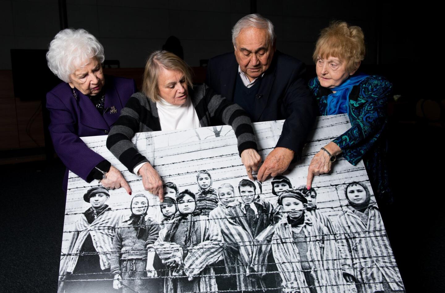 Survivors with photo of themselves at Auschwitz