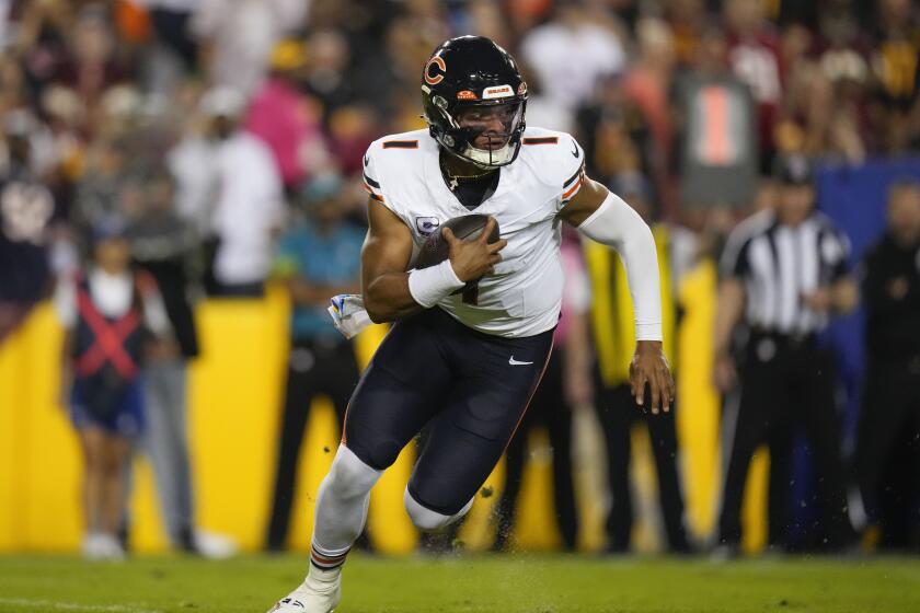 Chicago Bears quarterback Justin Fields (1) runs with the ball during the first half of an NFL football game against the Washington Commanders, Thursday, Oct. 5, 2023, in Landover, Md. (AP Photo/Alex Brandon)