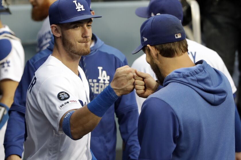 Los Angeles Dodgers' Cody Bellinger, left, bumps fist with Clayton Kershaw before the team's baseball game against the Colorado Rockies on Friday, June 21, 2019, in Los Angeles. (AP Photo/Marcio Jose Sanchez)