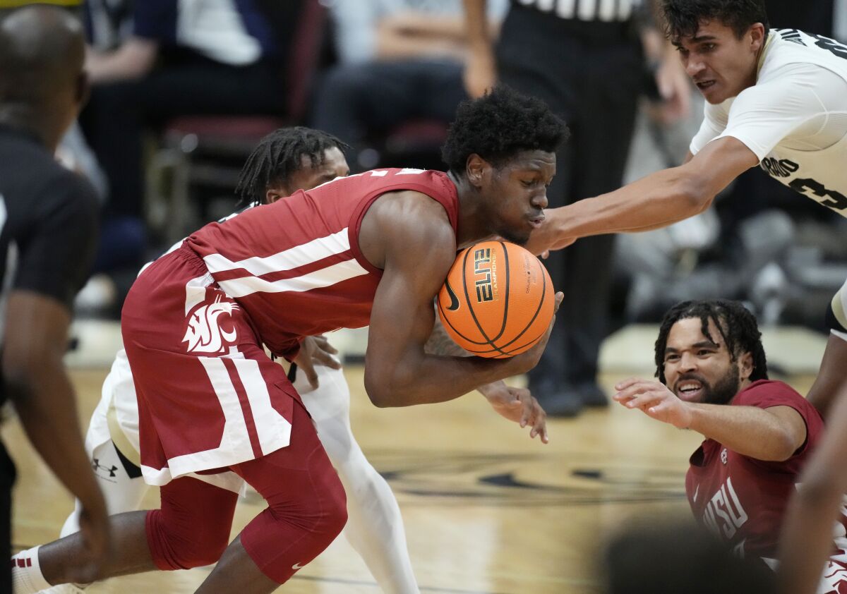 Washington State guard T.J. Bamba, front left, recovers the ball as Colorado guard Keeshawn Barthelemy, back left, and Colorado forward Tristan da Silva, front right, defend while Washington State guard Michael Flowers looks on in the second half of an NCAA college basketball game Thursday, Jan. 6, 2022, in Boulder, Colo. (AP Photo/David Zalubowski)