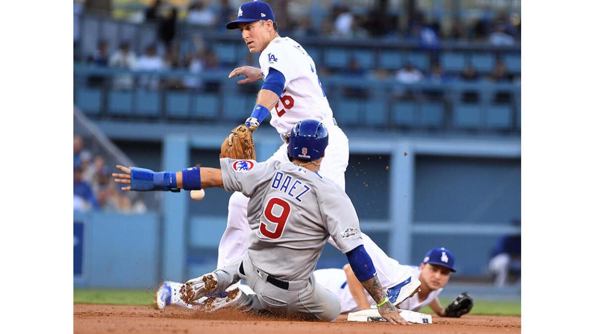 Dodgers Chase Utley drops the ball after a Corey Seager throw as Cubs Javier Baez slides safely into 2nd base