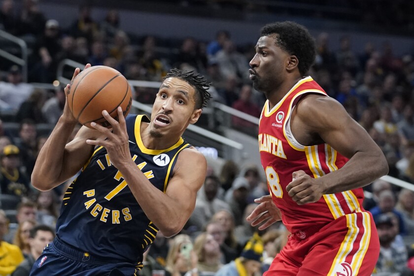 Indiana Pacers' Malcolm Brogdon (7) goes to the basket against Atlanta Hawks' Solomon Hill (18) during the second half of an NBA basketball game Wednesday, Dec. 1, 2021, in Indianapolis. (AP Photo/Darron Cummings)