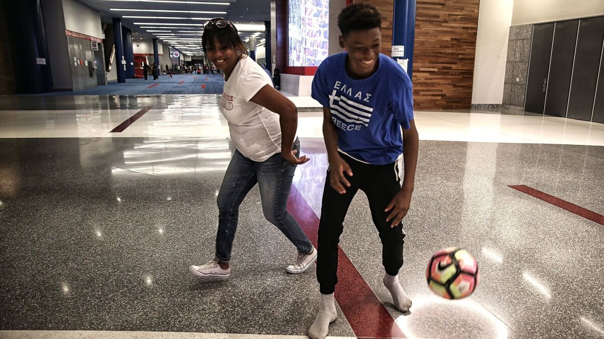 Yvonne Ferguson-Smith and her son, Travis, play in the halls of the George R. Brown Convention Center