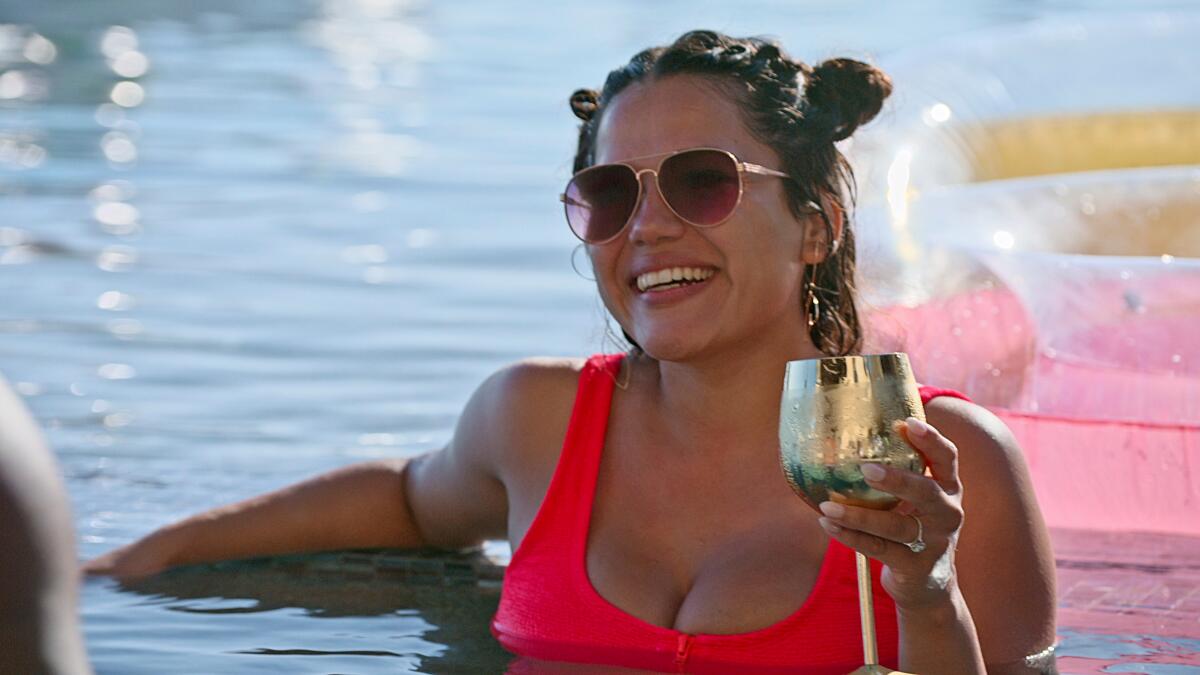A smiling woman having a drink in a pool