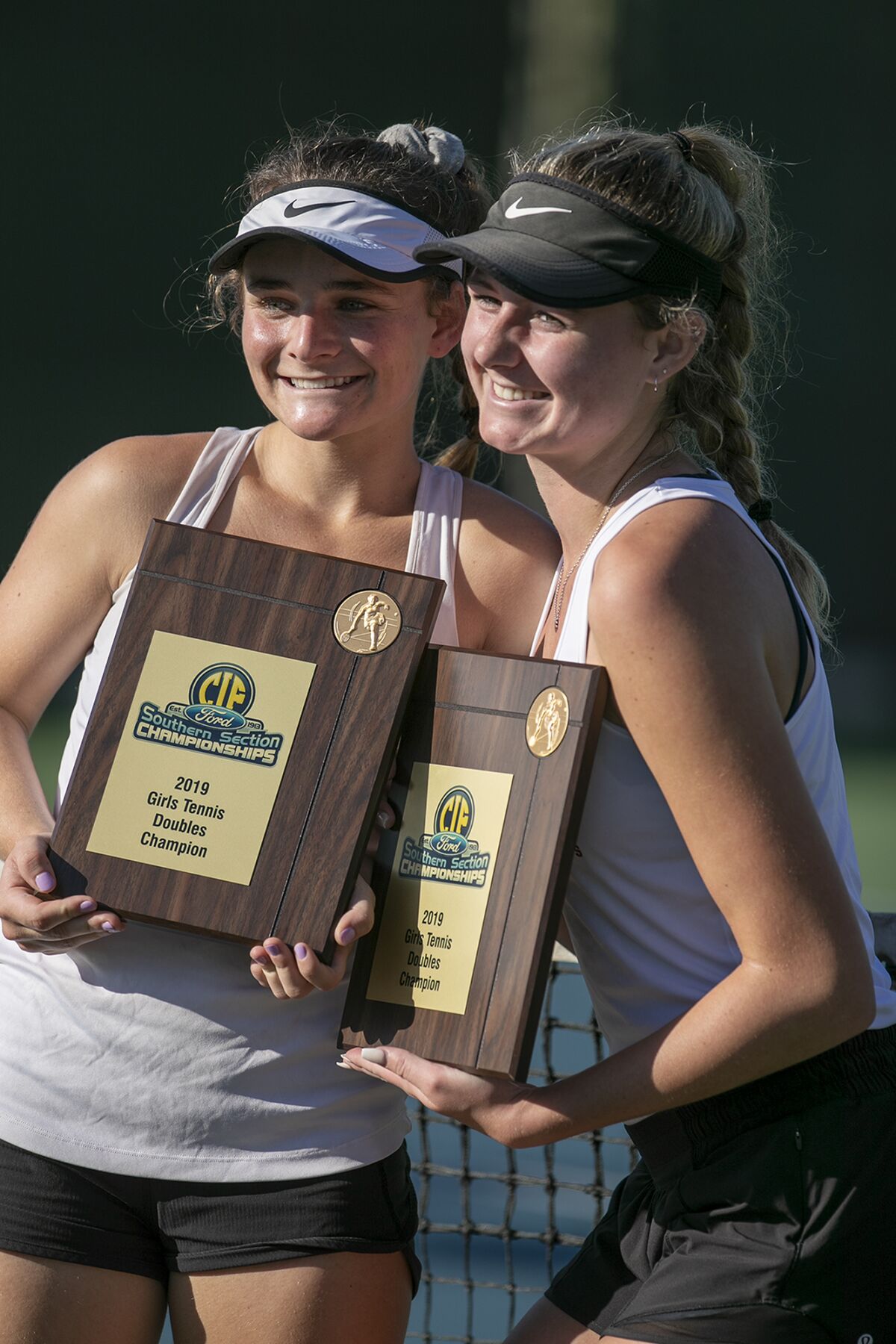 Laguna Beach's Sarah MacCallum, left, and Ella Pachl pose with the CIF Southern Section Individuals doubles championship plaques on Monday at Seal Beach Tennis Center.