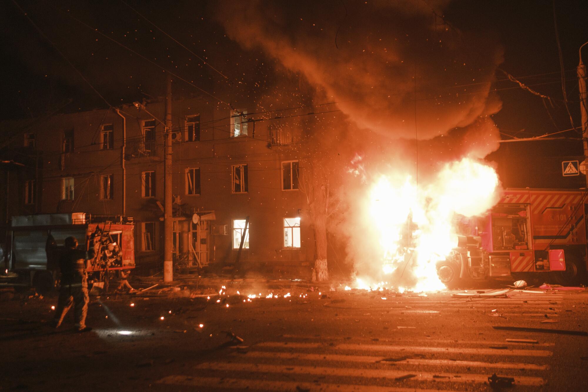 A fireball erupts near buildings at night