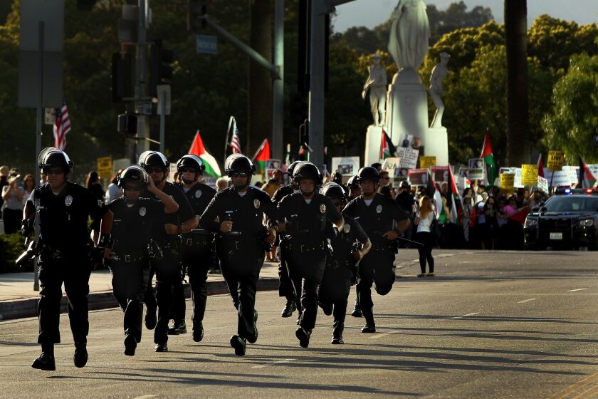 Police in riot gear respond to clashes at a pro-Israel rally at the federal building in Westwood on Sunday.