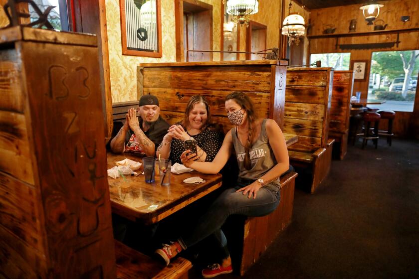(From L-R), Jeremiah Pino, Lydia Perez, of Marysville, and Aimee Roux, enjoy their first night out in weeks at the Silver Dollar Saloon in Marysville on Tuesday. "This is nice, enjoying the evening out with friends," said Perez.