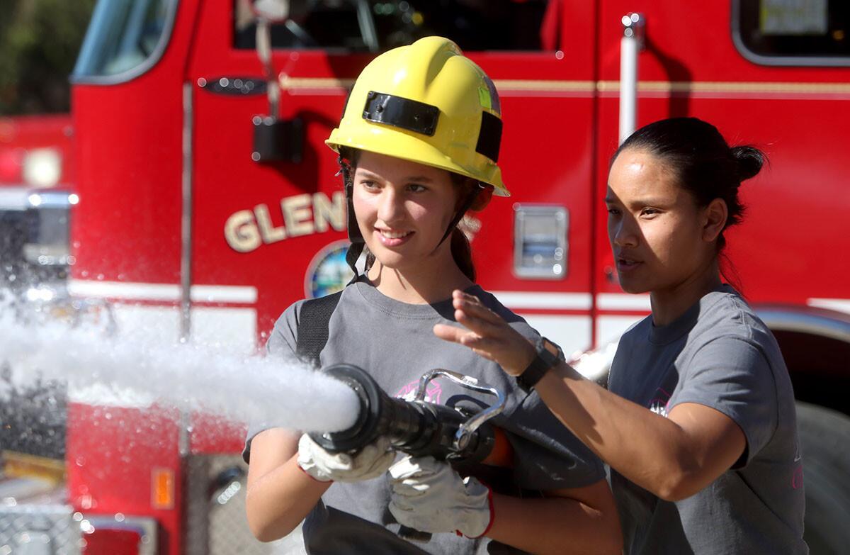 Highland Park resident Amanda Miranda, 14, learns how to control a hose from Ambulance Operator Bao-An Nguyen at the first Glendale Fire Dept. Girls Camp, at Station 21 in Glendale on Saturday, Nov,. 3, 2018. Participants, eight girls and one boy, ranged in age from 10 to 18 and participated in stations set up like auto extrication, aerial ladder climb, search and rescue, controlling a water hose, and manipulating a chainsaw.