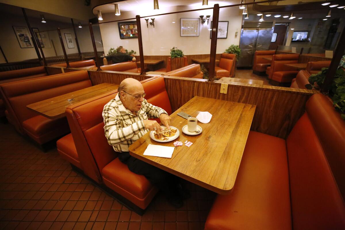 A man eats breakfast alone at a deli