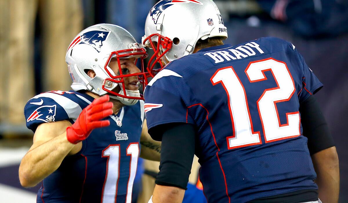 Patriots receiver Julian Edelman (11) is congratulated by quarterback Tom Brady after returning a punt for a touchdown in the second quarter Sunday.