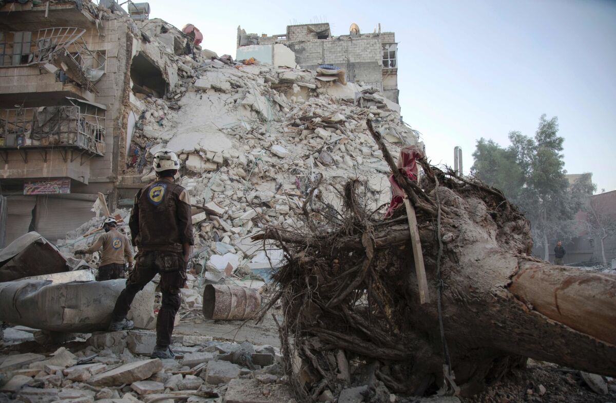 A member of the Syrian Civil Defense stands amid the rubble of a building during a rescue operation following reported airstrikes in a rebel-held area of Aleppo on Oct. 17