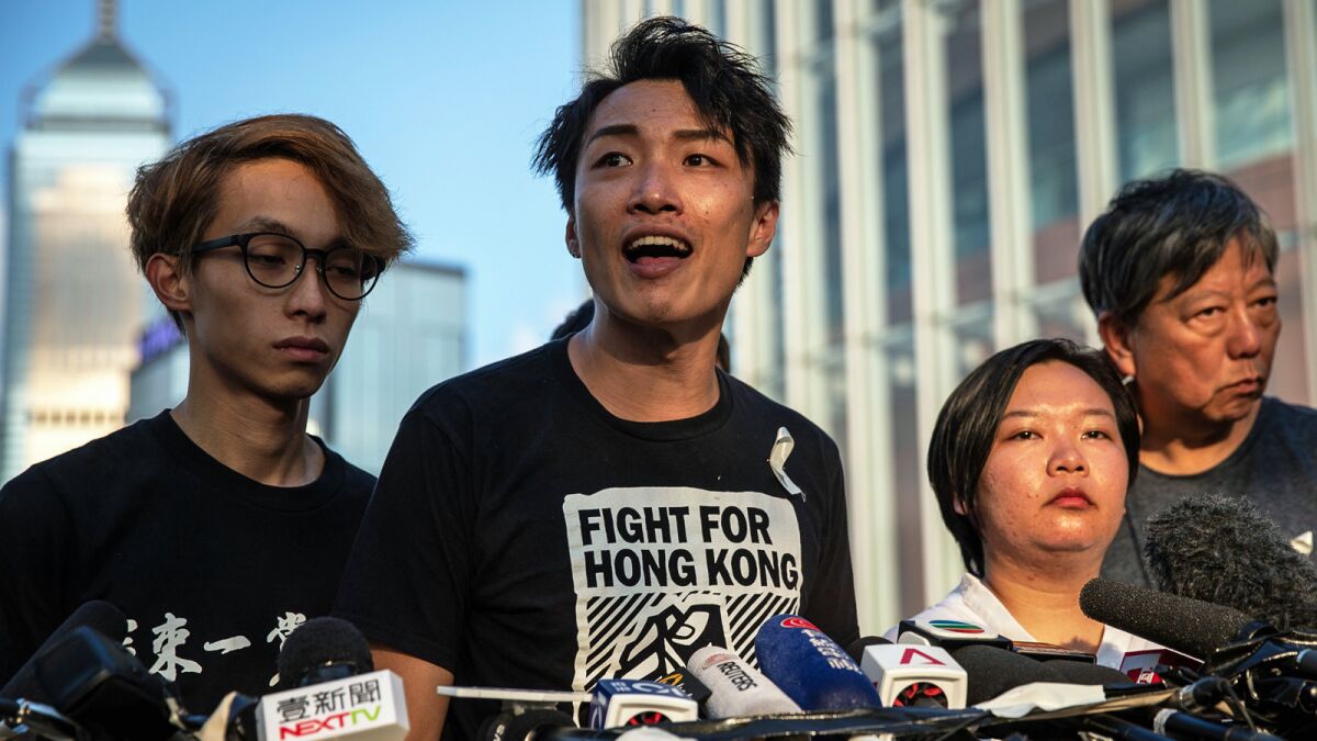 Jimmy Sham, center, a member of the Civil Human Rights Front, speaks Saturday at a news conference near the Legislative Council building in Hong Kong.