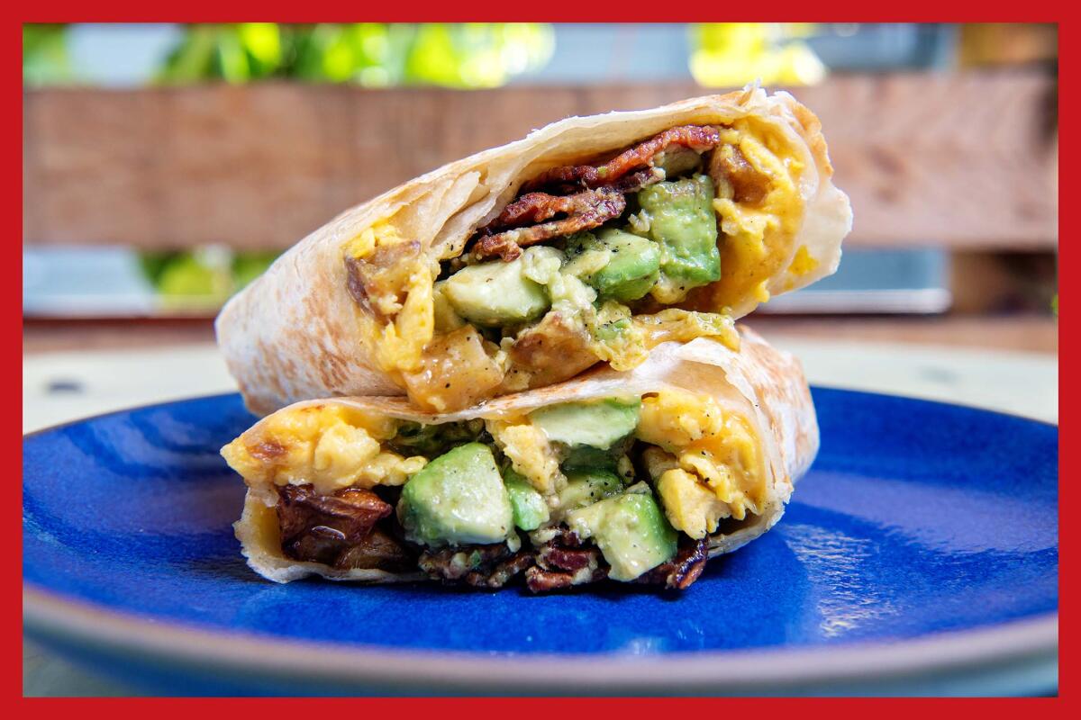 A cut-open and stacked breakfast burrito on a blue plate.