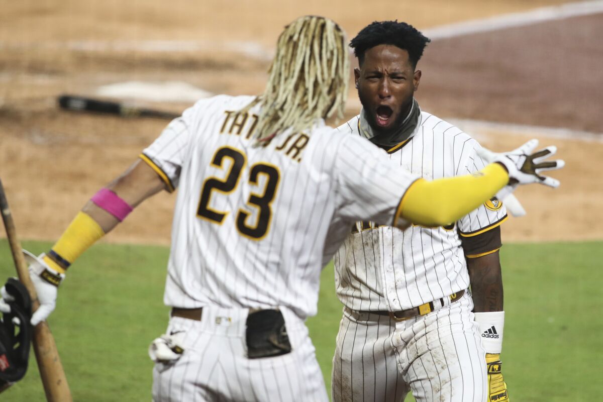 San Diego Padres' Jurickson Profar, right, reacts after scoring on a fielder's choice in the seventh inning of a baseball game against the Los Angeles Dodgers, Monday, Sept. 14, 2020, in San Diego. (AP Photo/Derrick Tuskan)
