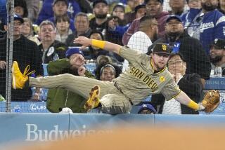 San Diego Padres' Jake Cronenworth falls against the netting after taking a catch on a ball in foul territory hit by Los Angeles Dodgers' Chris Taylor during the 11th inning of a baseball game Friday, April 12, 2024, in Los Angeles. (AP Photo/Mark J. Terrill)