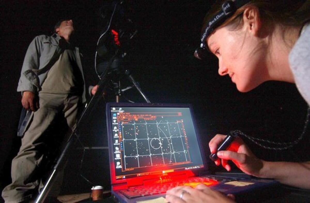 KEEPERS OF THE NIGHT SKY: Dan Duriscoe, left, aims a digital camera at the sky as Night Sky Team colleague Angie Richman confirms its position by computer at Arches National Park, where there is relatively little light pollution.