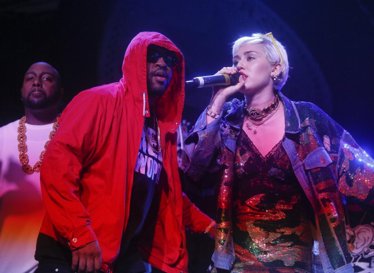 Miley Cyrus, right, joins Mike Will Made It onstage during his performance at South by Southwest.