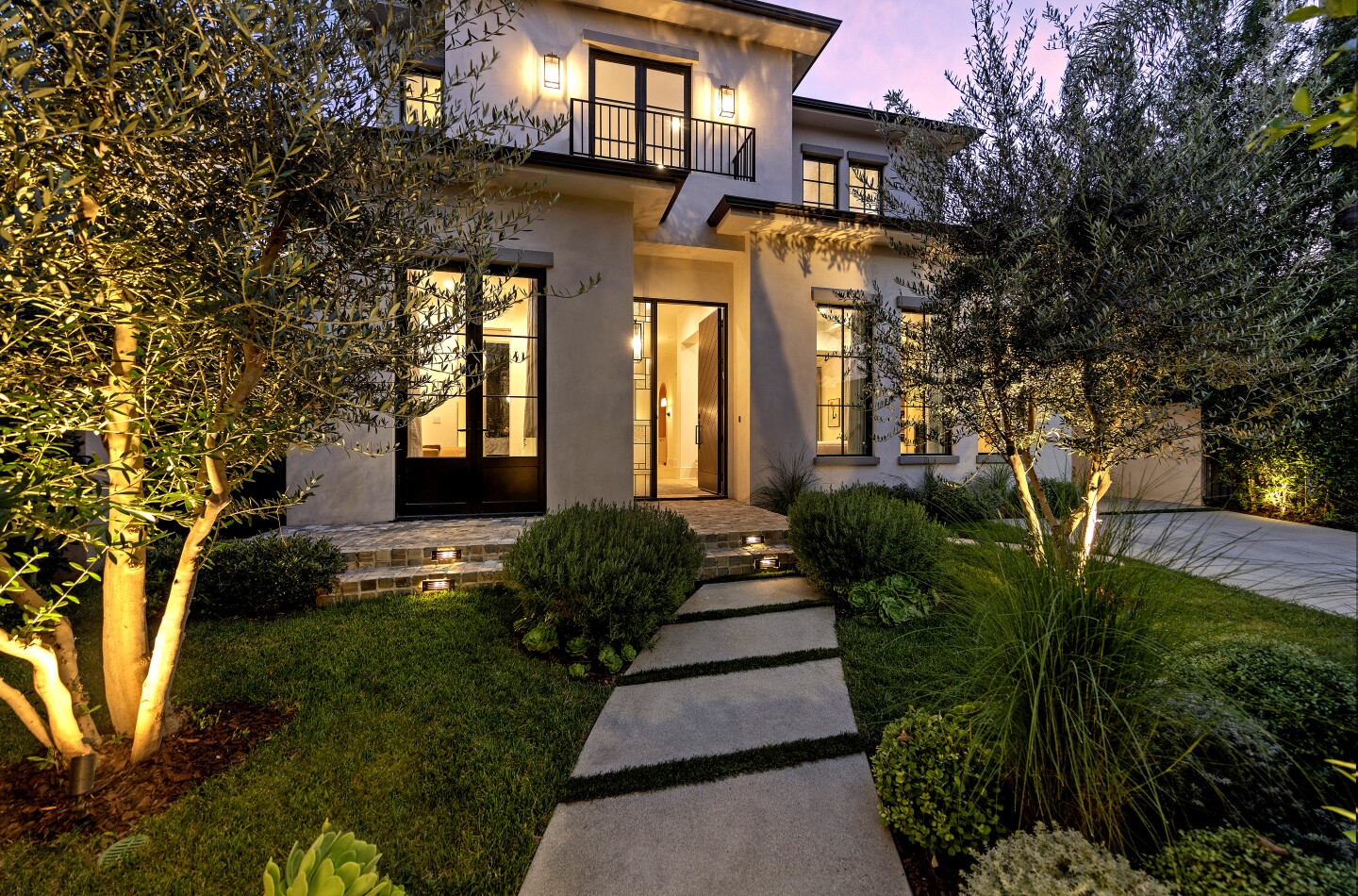 The newly built spec house includes a contemporary-style main house with earthy tones, a guesthouse and a backyard with a saltwater pool, spa, bar and patio.