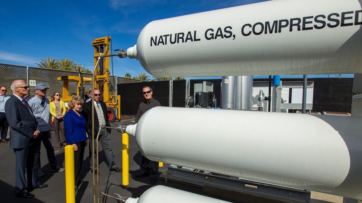 Huntington Beach Union High School District officials tour the district's new compressed natural gas fueling station Monday.