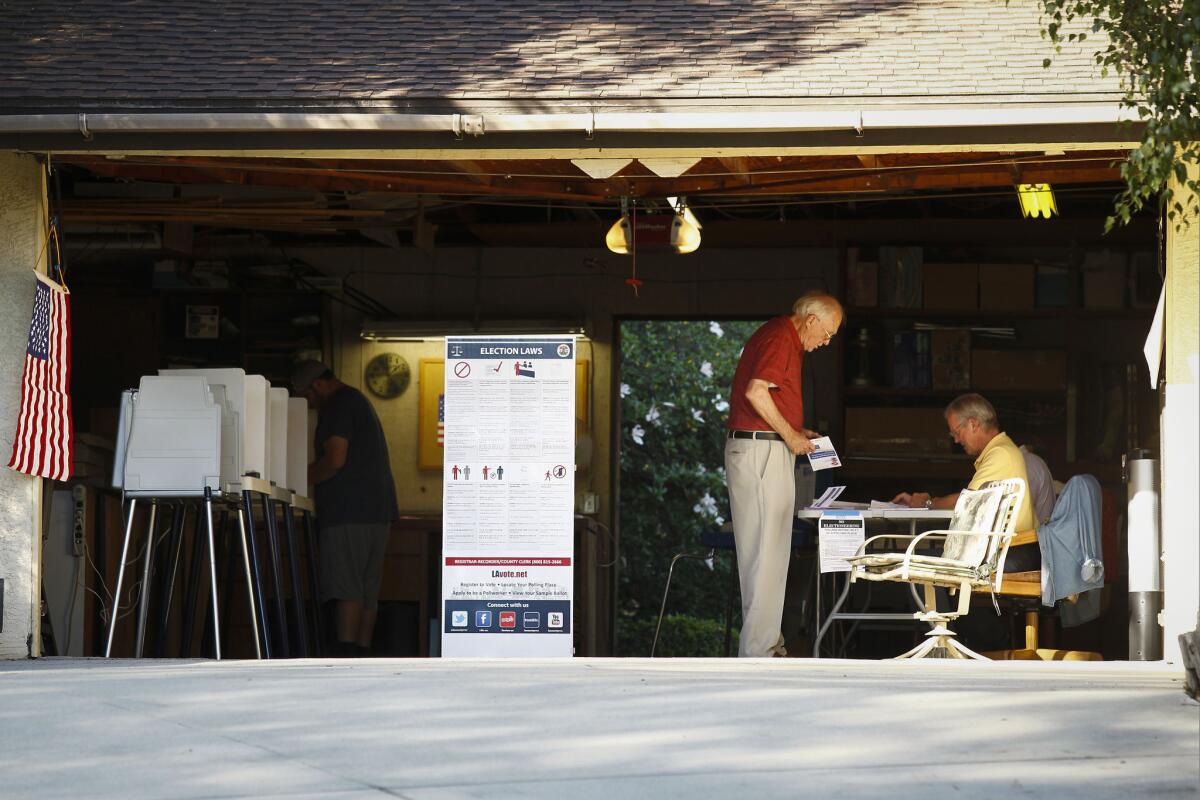Voters cast their ballots in the primary election at a polling place in a home garage in unincorporated Los Angeles County near Covina.