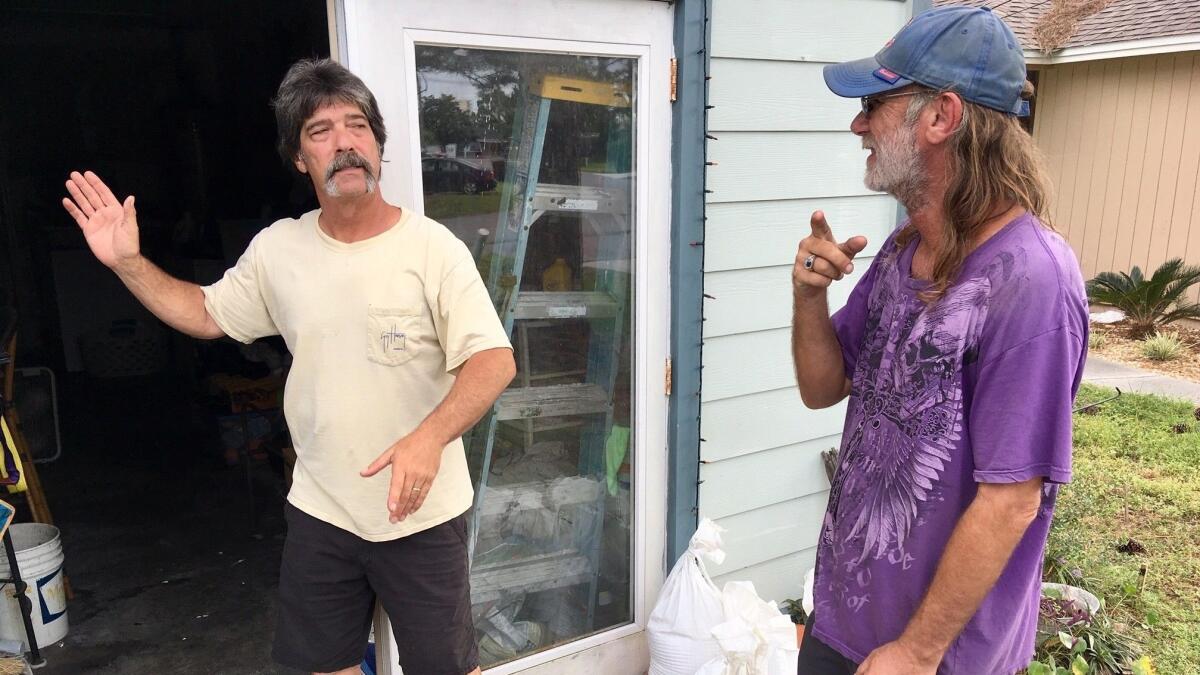 Dwight Williams, left, and Timothy Thomas discuss whether to evacuate their neighborhood in Panama City Beach, Fla., on Oct. 9.