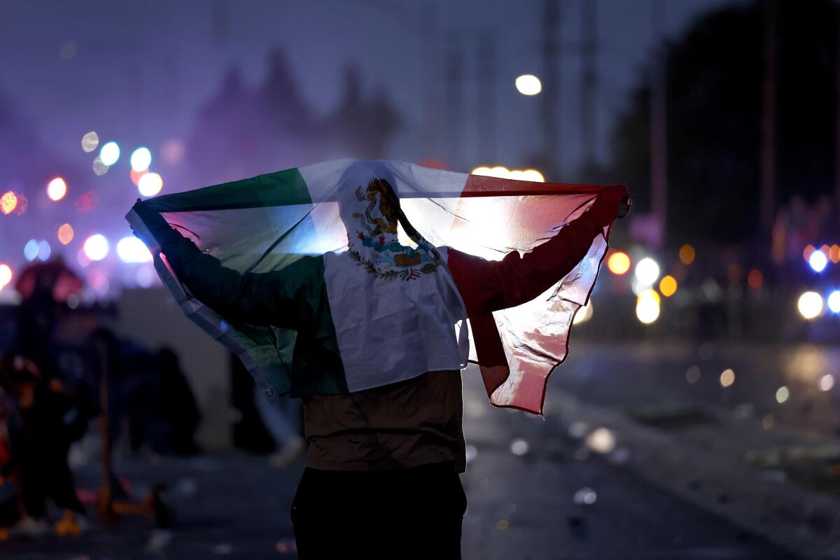A protester holds the Mexican flag during a protest