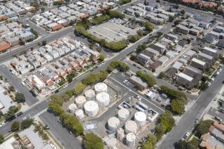 Huntington Beach, CA - July 13: An aerial view of oil wells and storage next to homes in Huntington Beach on Tuesday, July 13, 2021. The California Department of Conservation will soon be releasing a new rule about whether to require health and safety buffer zones around oil wells. (Allen J. Schaben / Los Angeles Times)