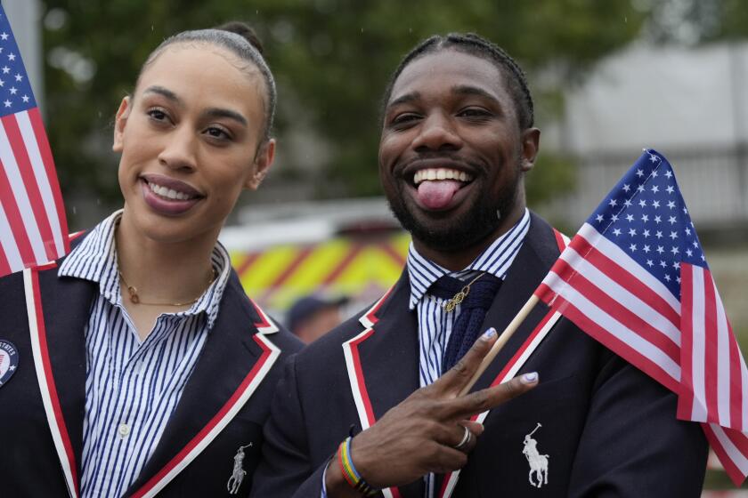El velocista estadounidense Noah Lyles (derecha) posa para fotos durante la ceremonia inaugural de los Juegos Olímpicos de París, el viernes 26 de julio de 2024. (AP Foto/Ashley Landis, Pool)
