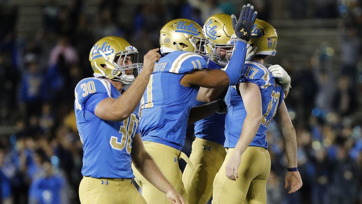 Bruins place kicker JJ Molson (right) is swarmed by teammates after he kicking the winning field goal in a 30-27 victory over California at the Rose Bowl on Nov. 24, 2017.