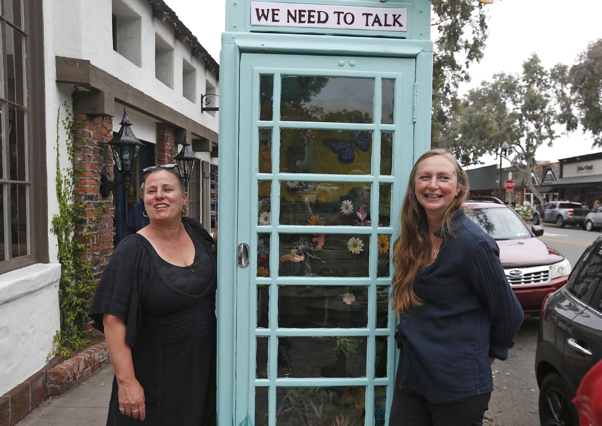 Artists Julie Setterholm and Candice Brokenshire, from left, stand at their new public art installation in Laguna Beach.