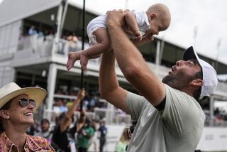 Scottie Scheffler holds his son Bennett Ezra Scheffler as his wife Meredith Scudder looks.