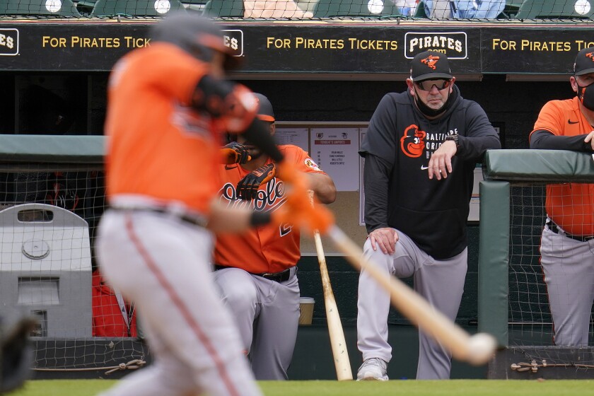 Baltimore Orioles manager Brandon Hyde, right, stands in the dugout steps as Yolmer Sanchez bats during the fourth inning of a spring training exhibition baseball game against the Pittsburgh Pirates in Bradenton, Fla., Monday, March 22, 2021. (AP Photo/Gene J. Puskar)