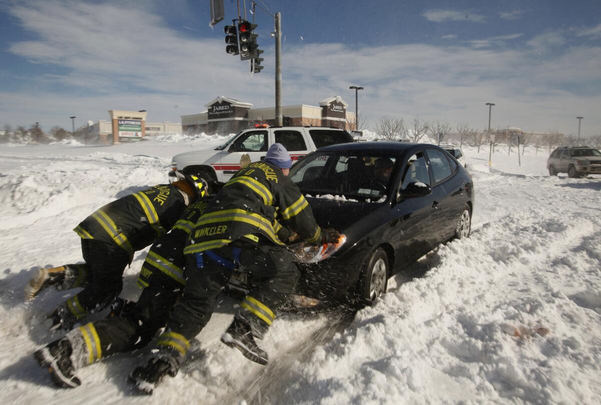 Members of the Nissequogue Fire Department assist a stranded motorist in Suffolk County, N.Y., where a group of people took shelter at a Wal-Mart store.