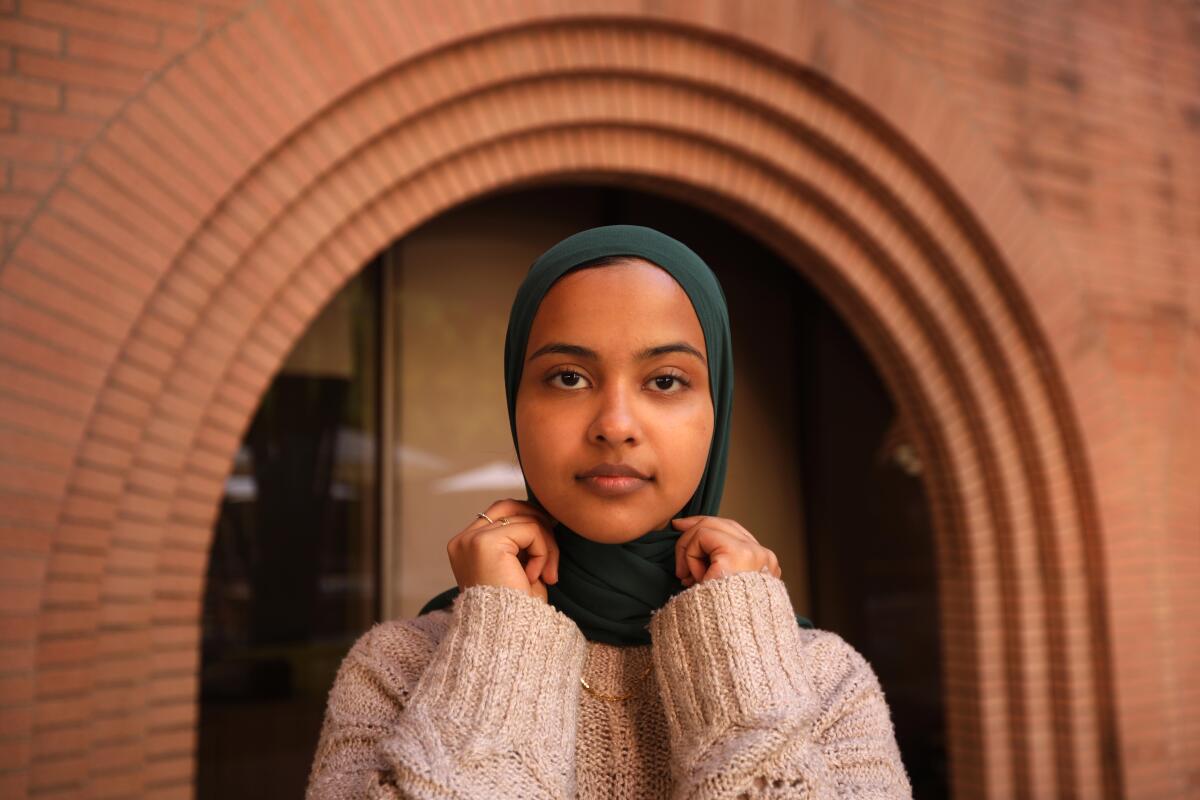 A woman is wearing a green headscarf. 