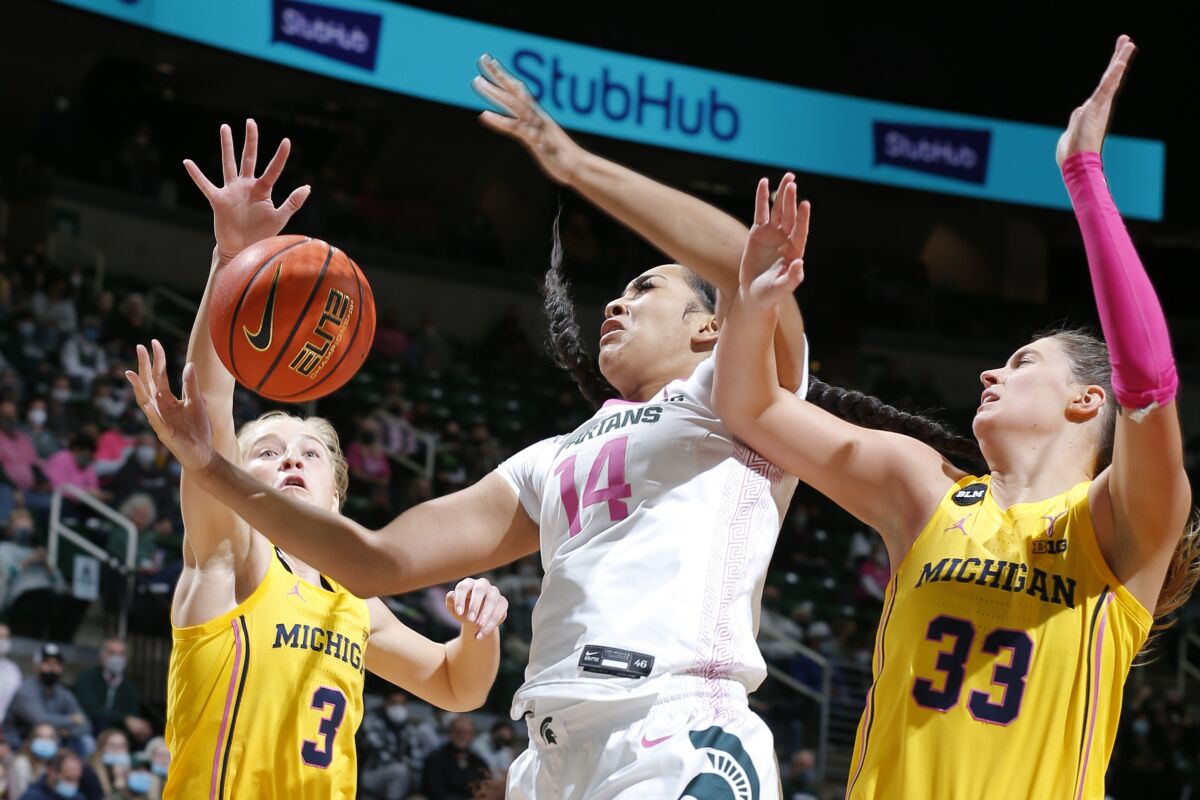 Michigan State's Taiyier Parks, center, and Michigan's Maddie Nolan, left, and Emily Kiser (33) vie for the ball during the first half of an NCAA college basketball game, Thursday, Feb. 10, 2022, in East Lansing, Mich. (AP Photo/Al Goldis)