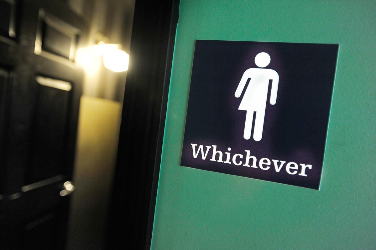 A gender-neutral sign is posted outside a bathroom at Oval Park Grill in Durham, N.C., in May.