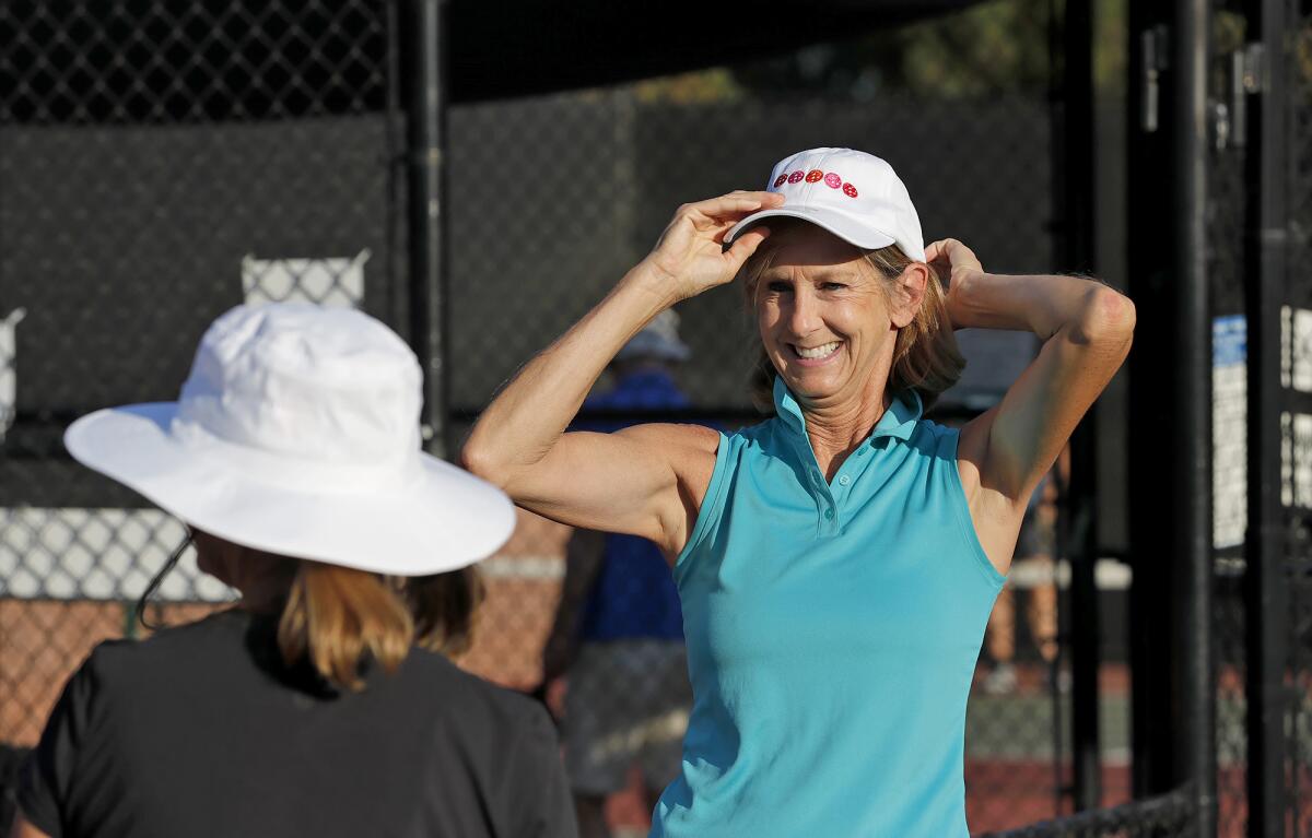 Sue Murphy, right, adjusts her hat while Kristen Ridge waits to start a pickleball match.